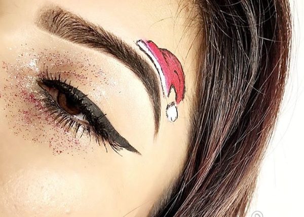 Sombras de ojos con purpurina, gorro de Papá Noel en la ceja y delineador de ojos negro #Navidad #maquillaje #belleza #trendypins