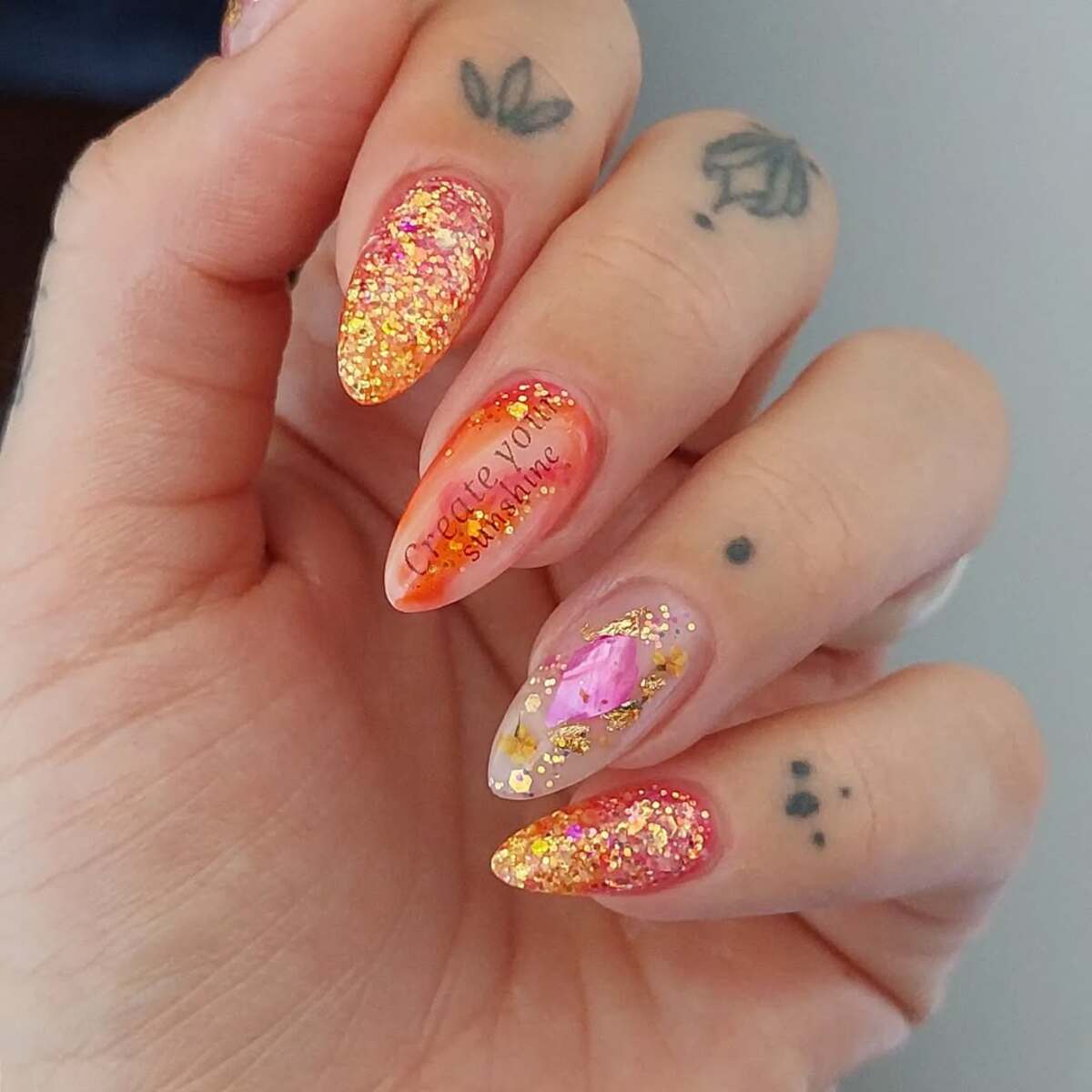 7. Fiery Sunset Almond Nails with Glitter and Foil Accents