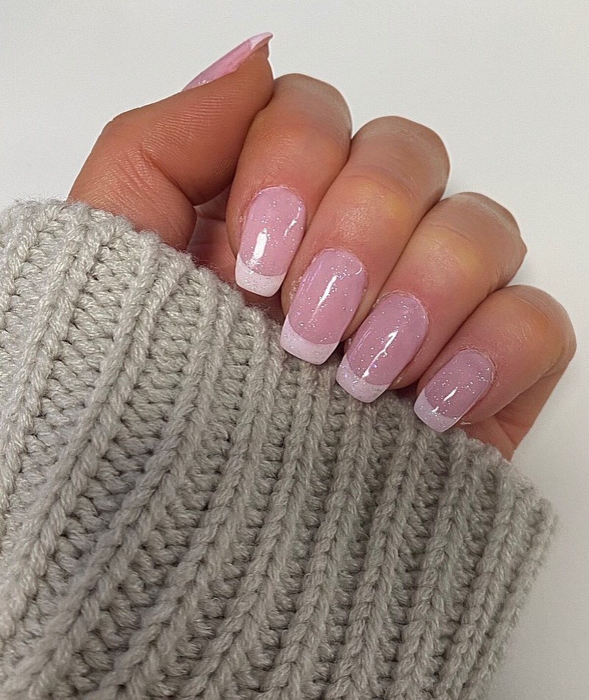 22. Classic French Tips with a Glittery Touch