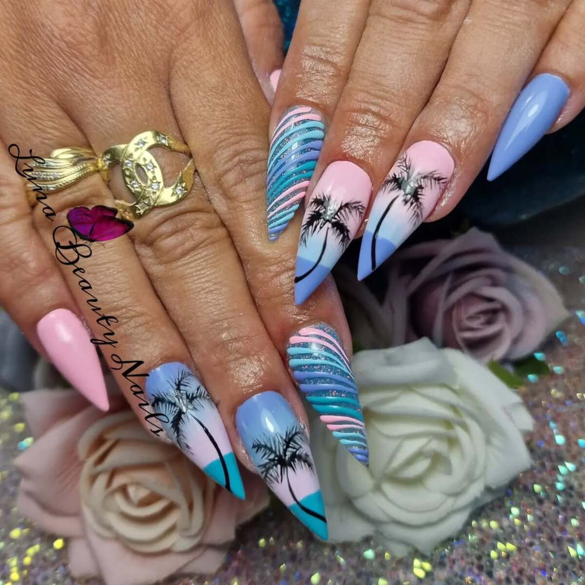 25. Dreamy Sunset Stiletto Nails with Palm Tree Accents