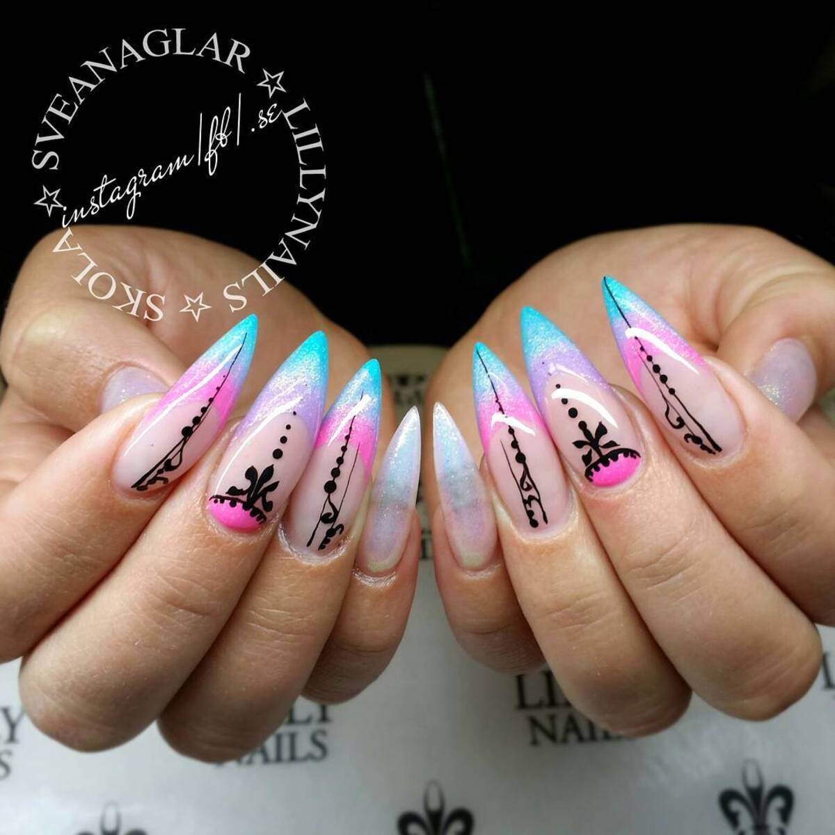 3. Ethereal Ombré Stiletto Nails with Intricate Black Accents