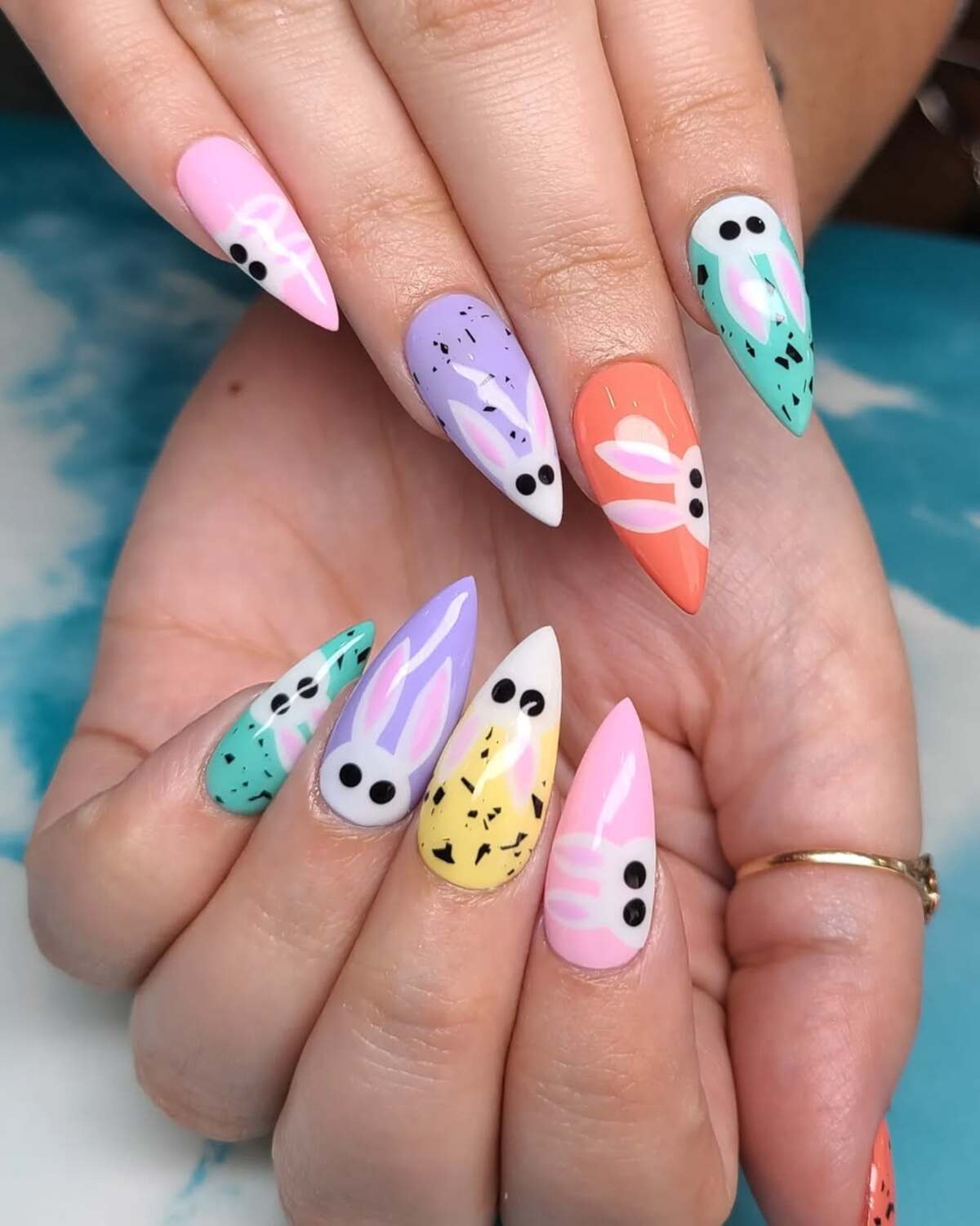 8. Bold Bunny Faces on Speckled Pastel Nails