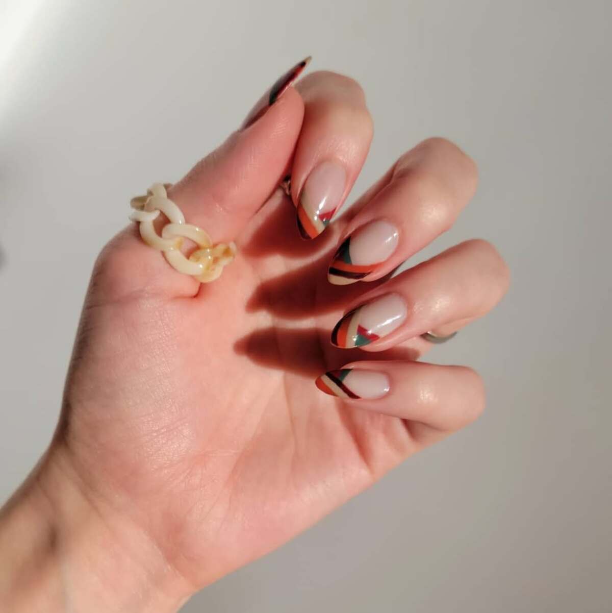 7. Warm-Toned French Tips with Abstract Lines