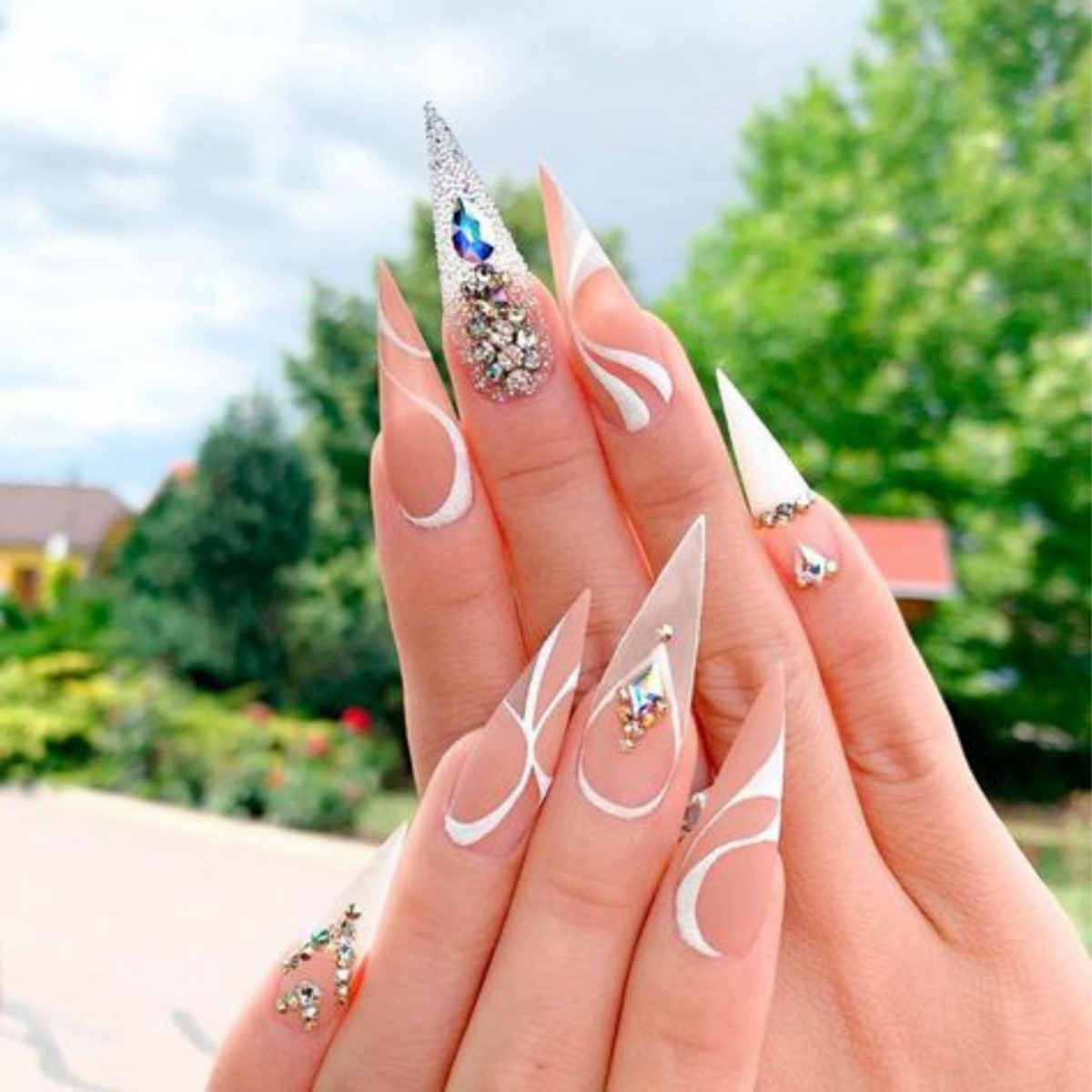 8. Futuristic White Stiletto Nails with Crystal Accents