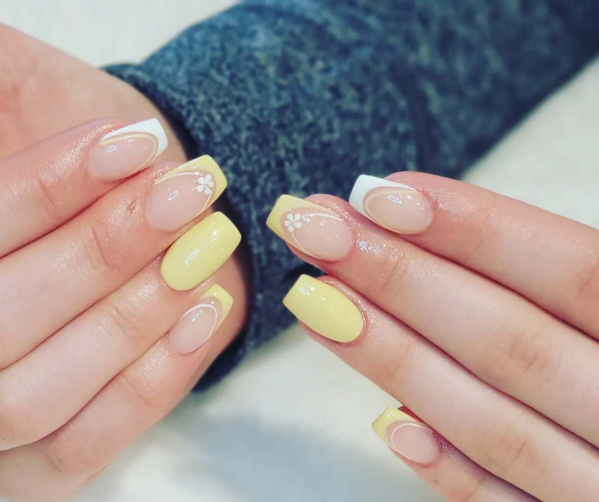 11. Soft Pastel Yellow French Tips with Floral Accents