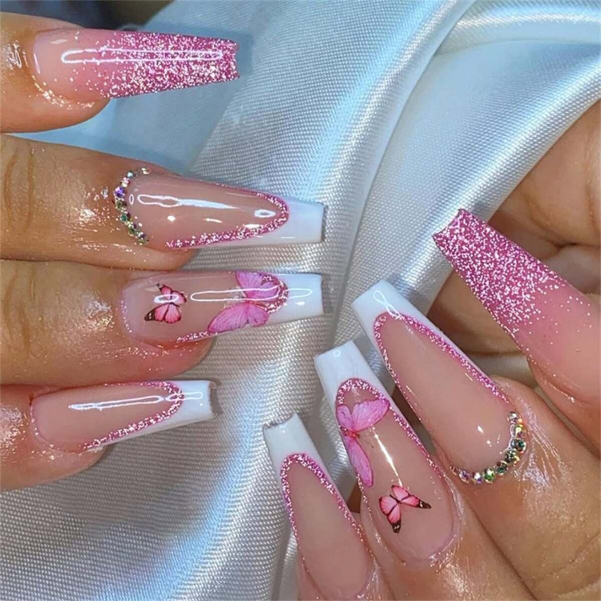 15. Sparkling Pink French Tips with Butterfly Accents
