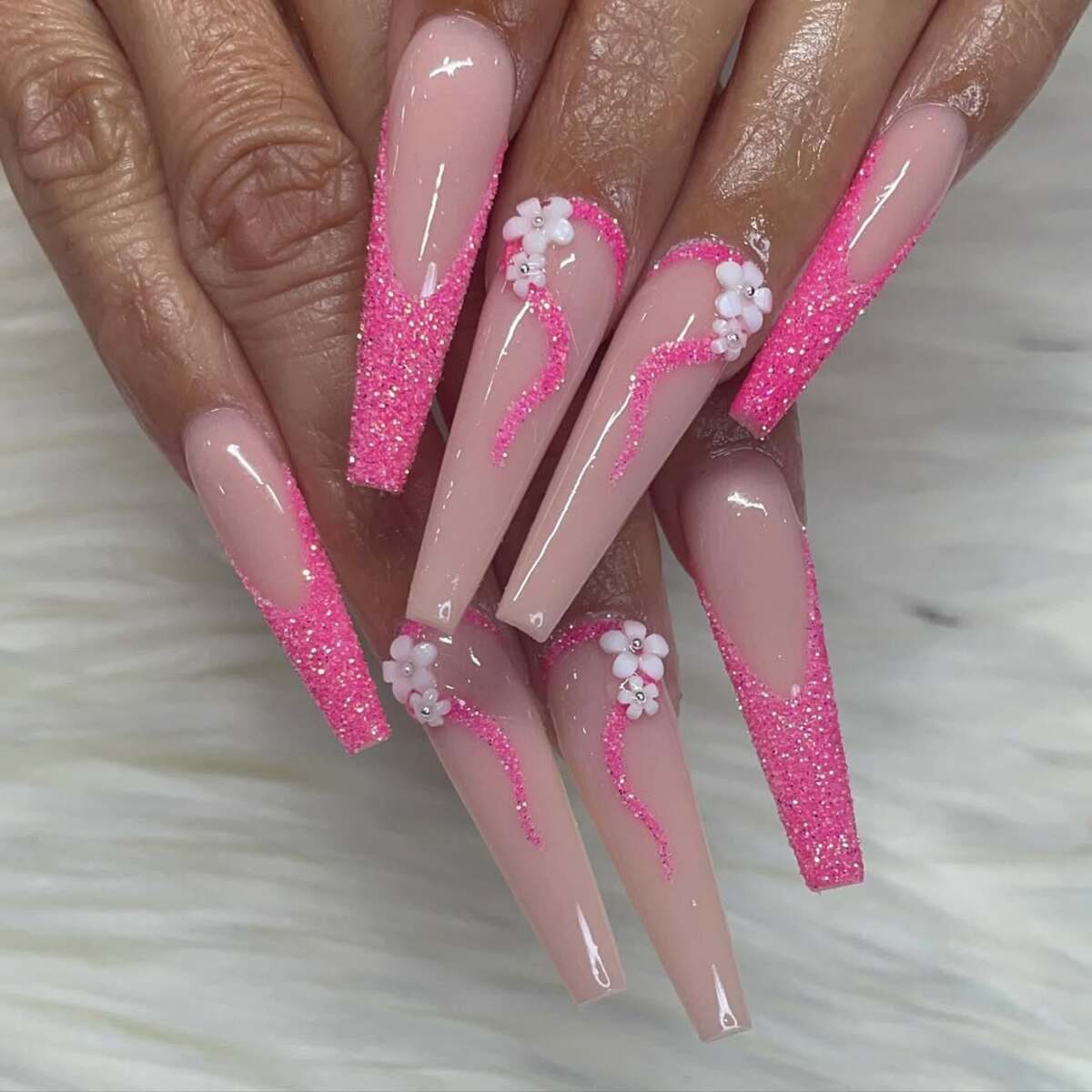 19. Bold Pink Glitter French Tips with Floral Accents