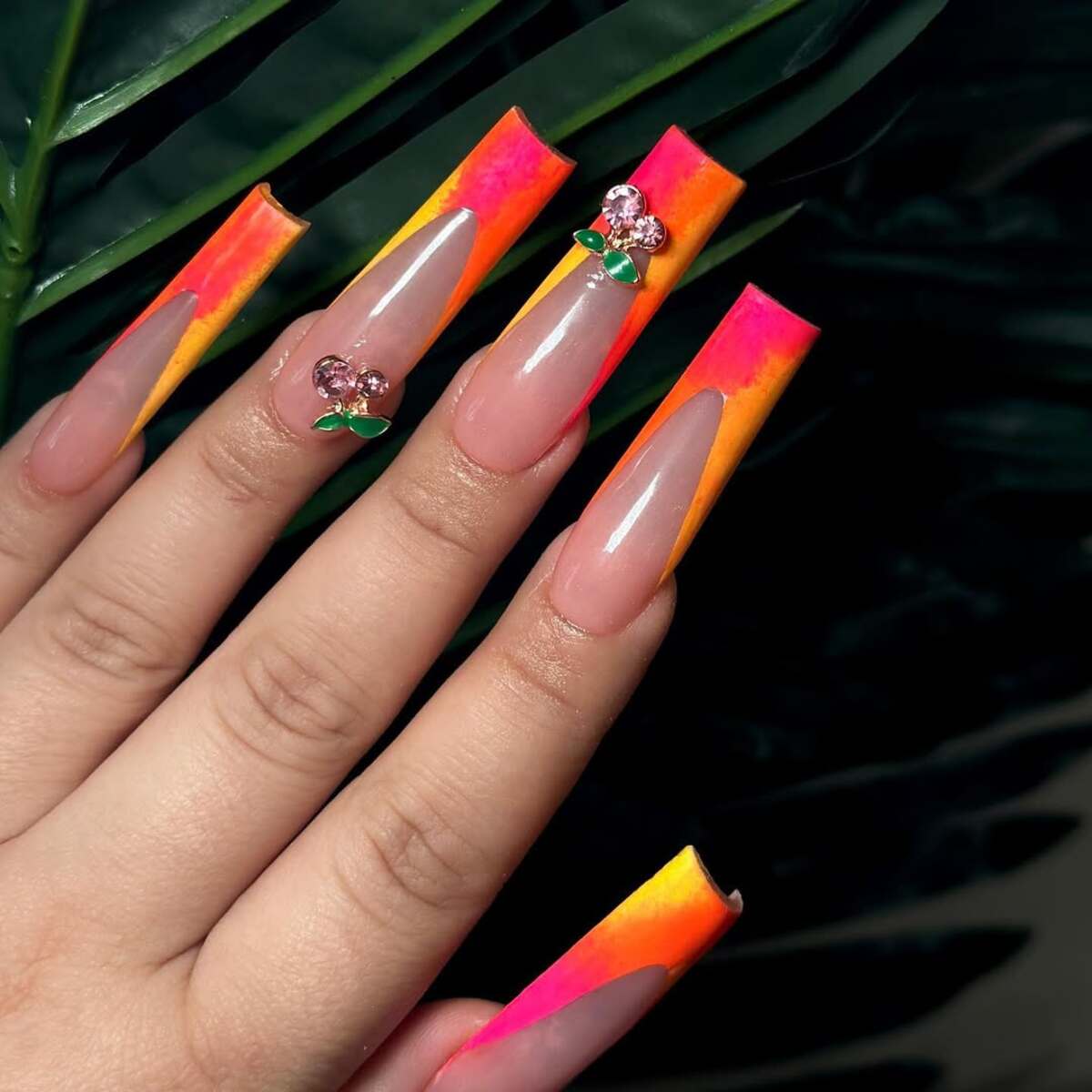 13. Neon Sunset French Tips with Cherry Accents