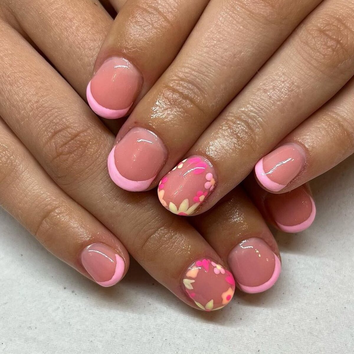 23. Soft Pink French Tips with Floral Accents