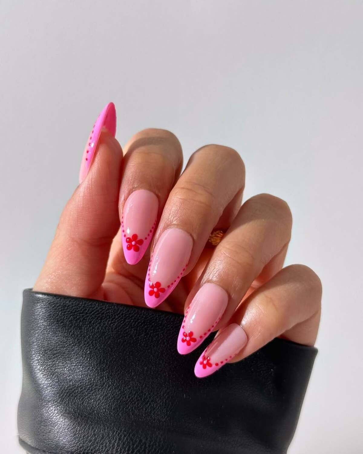 7. Bold Pink French Tips with Red Floral Accents