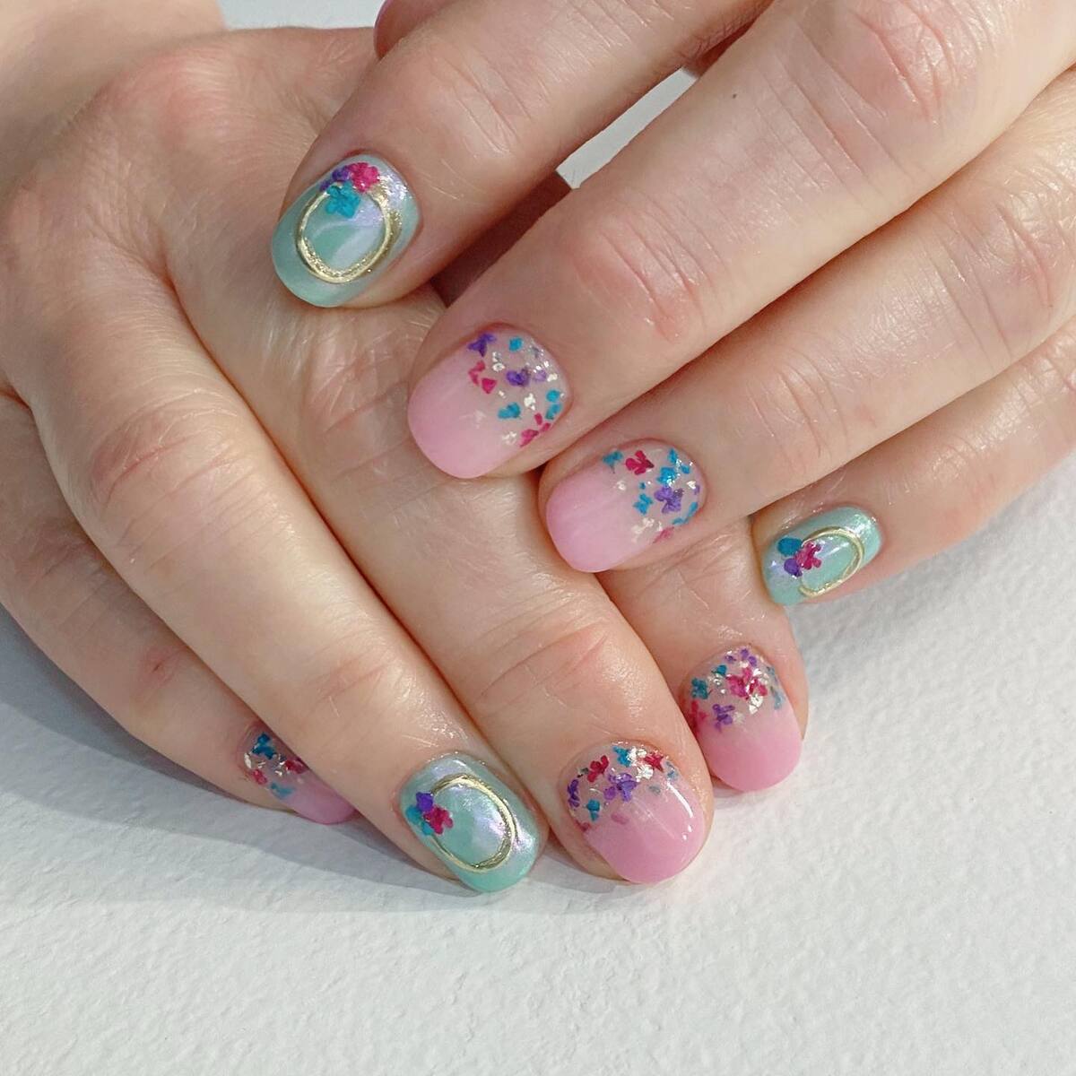 23. Pastel French Tips with Glittering Floral Confetti