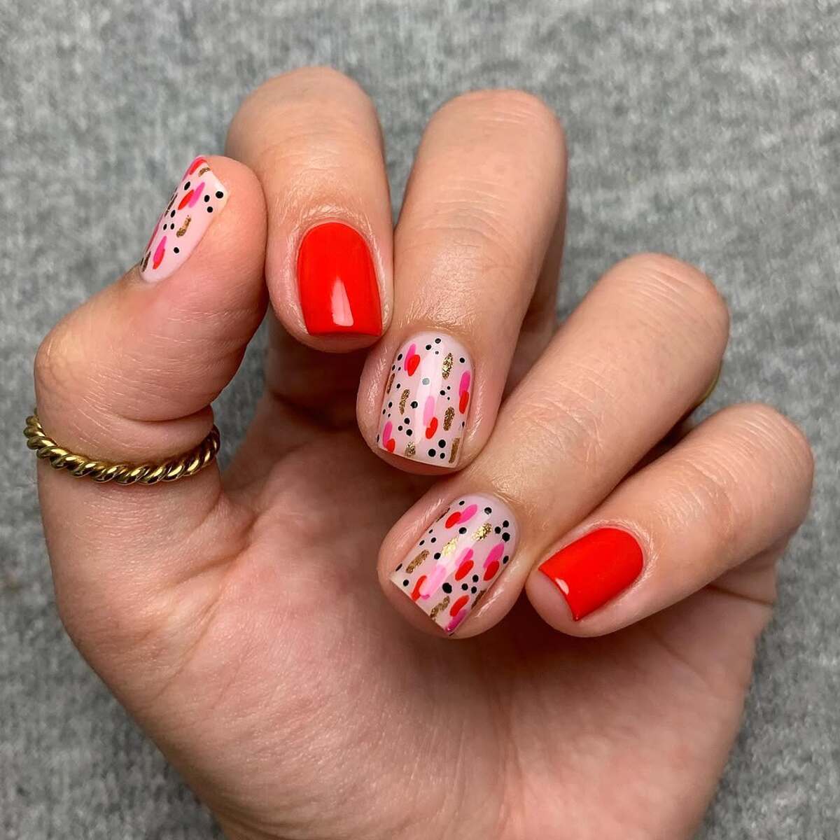 9. Short Red Nails with Abstract Gold and Pink Accents