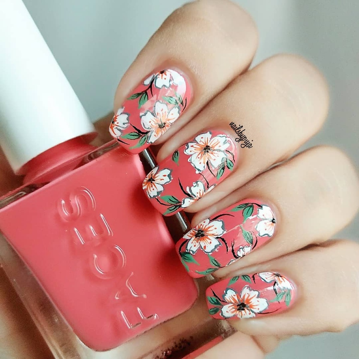 10. Bold Floral Print on Coral Nails