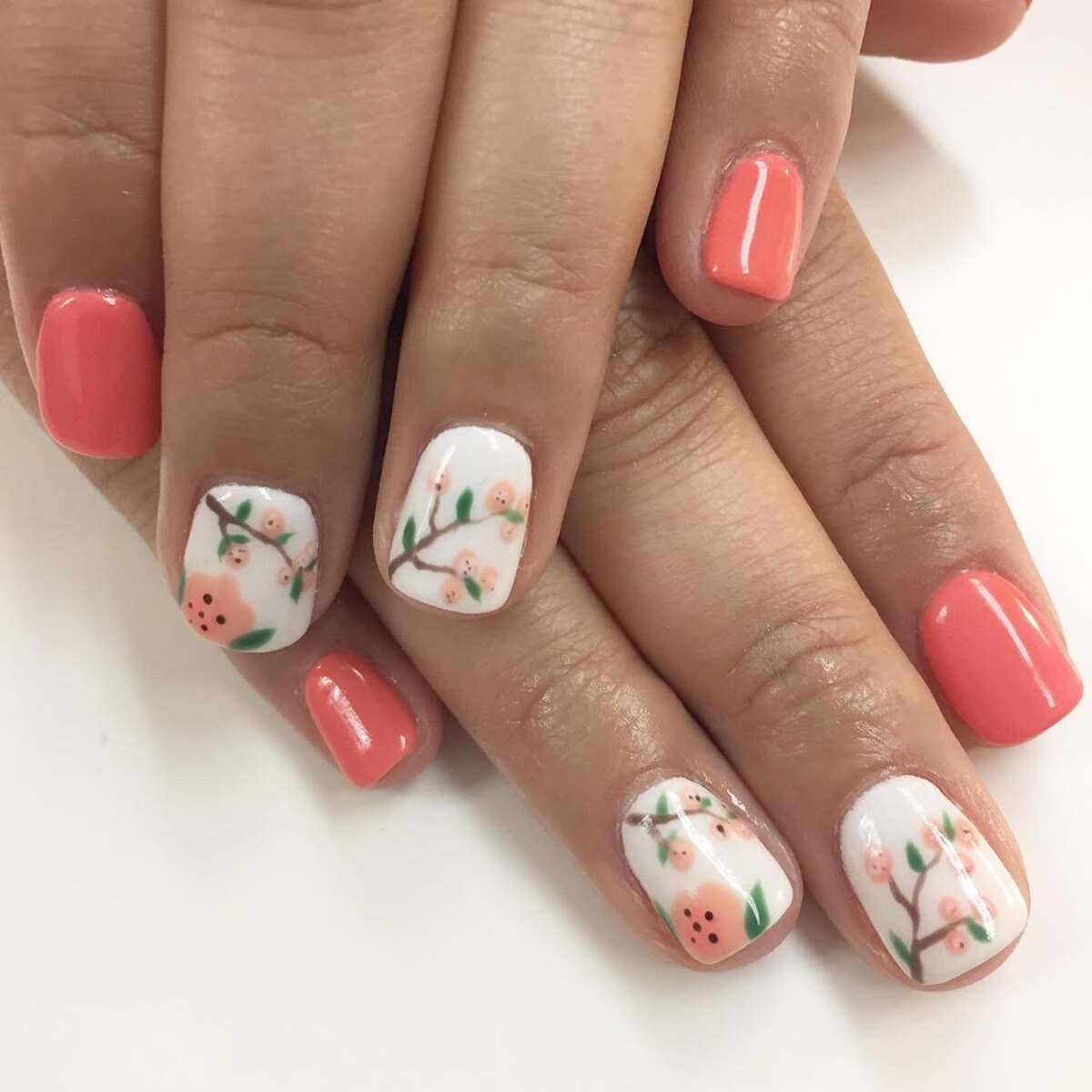 9. Delicate Blossom Nail Art on Coral Base