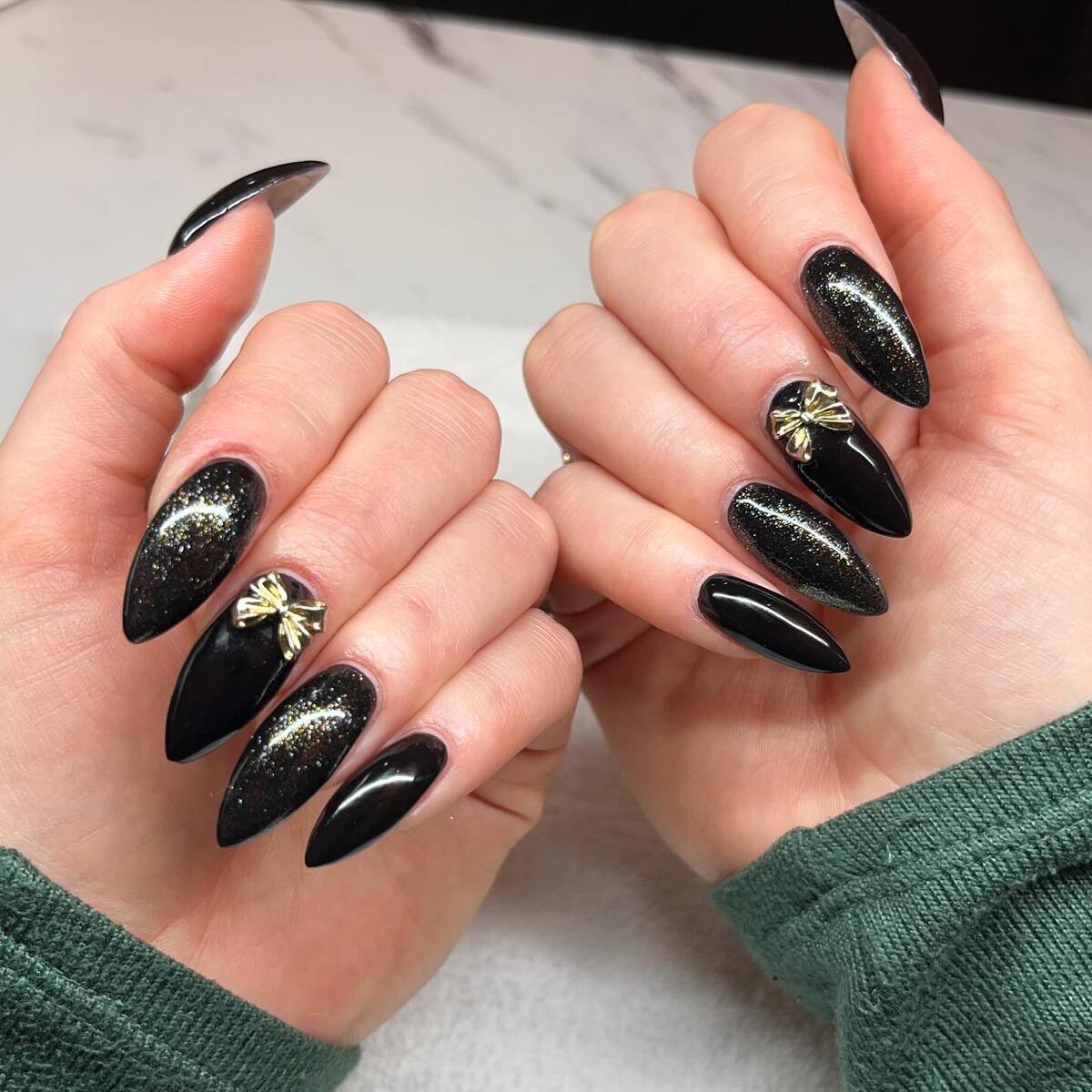 14. Sleek Black Christmas Glam with Gold Bows