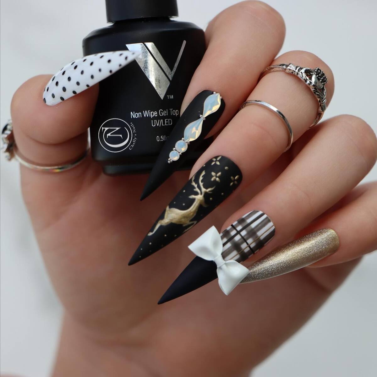 17. Elegant Black and Gold Christmas Reindeer Nails