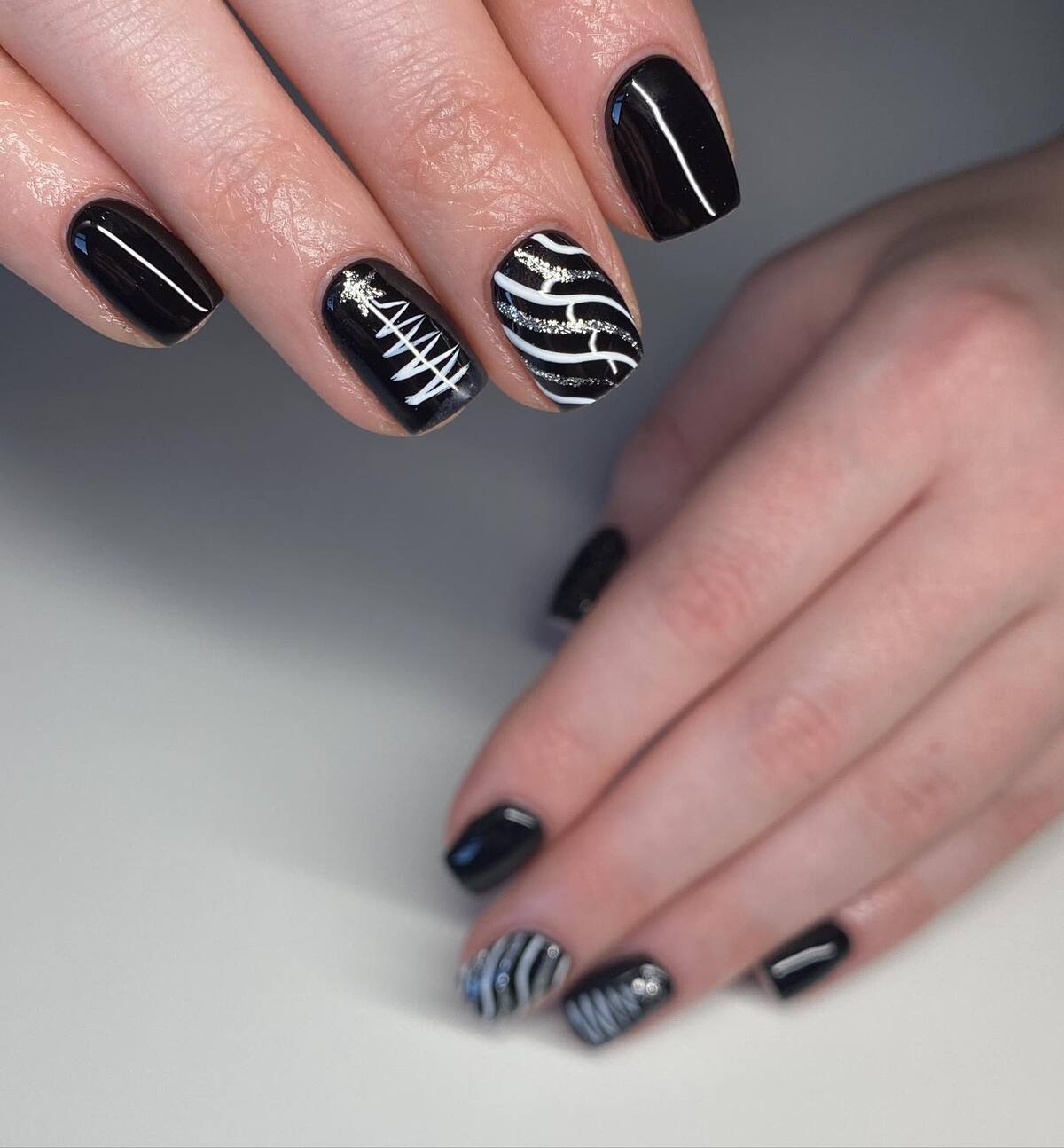2. Sleek Black Nails with Festive Silver Accents