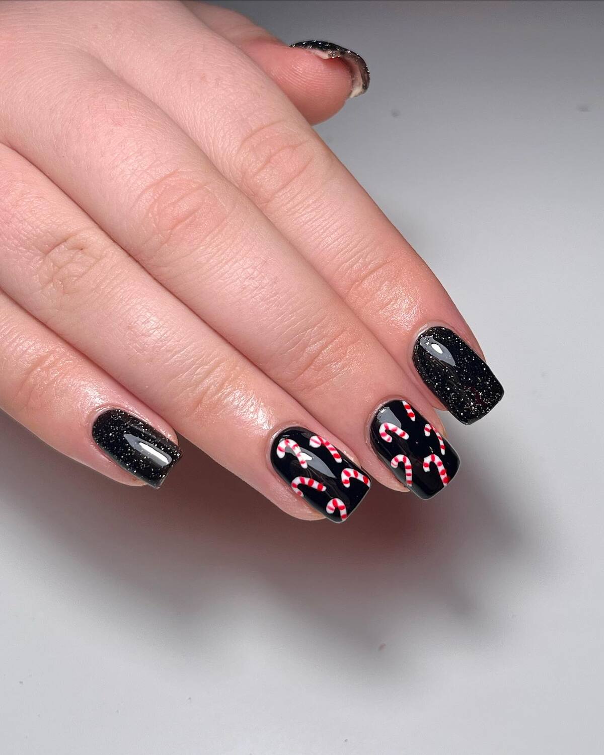 5. Chic Black Nails with Christmas Candy Canes