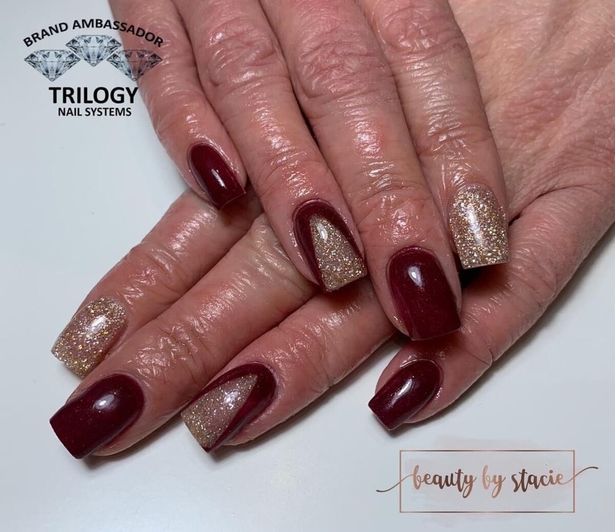 31. Elegant Burgundy Christmas Acrylic Nails with Gold Sparkle